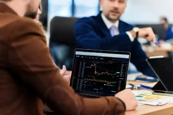 Investidor analisando gráficos no notebook